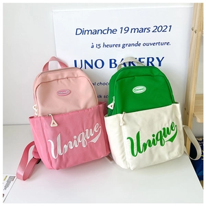Detail view of pink and green nylon backpacks with Unique embroidery and logo