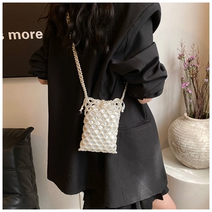 Detail of pearl woven crossbody bag with white drawstring pouch and woven shoulder strap