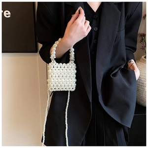 Détail du mini sac à main en perles blanches tressées avec bandoulière chaîne élégante