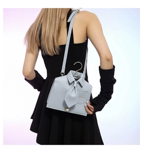 Detail of creative blue shirt-shaped shoulder bag with tie and golden hanger hook