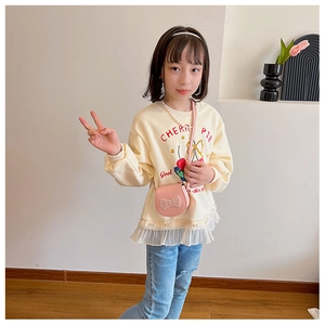 Détail d'un sweat-shirt crème pour filles avec dentelle et mini sac à bandoulière avec perles