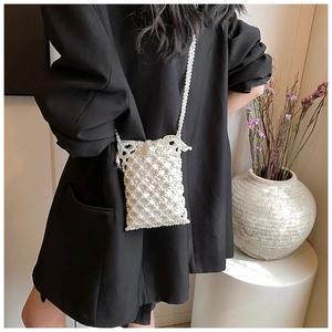 Close-up of pearl beaded crossbody bag showing woven texture and elegant white strap
