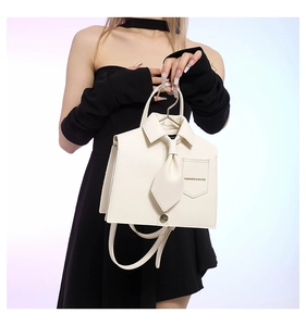 Detailed close-up of a shirt-shaped faux leather tote with collar and bowknot accents