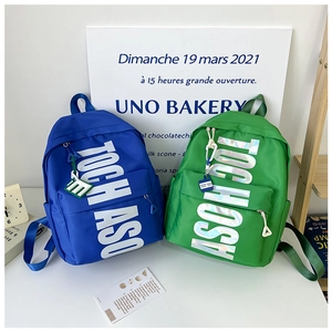 Detail view of stylish kids nylon backpacks with holographic letter prints and pendants