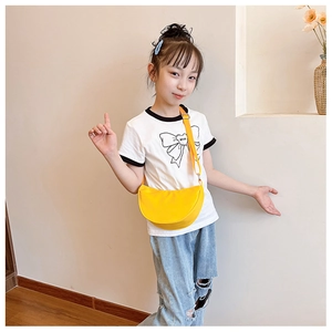 Detailed shot of a yellow half-moon crossbody bag with adjustable strap on a child model