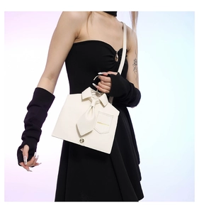 Detail of creative shirt-shaped white PU leather handbag with tie design and snap closure