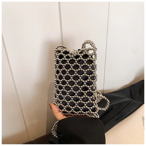 Detail of hand-woven silver beaded mini bag featuring black fabric lining and pearl strap