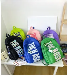 Detail view of colorful nylon backpacks with TOGHAS letters and letter E zipper pendants