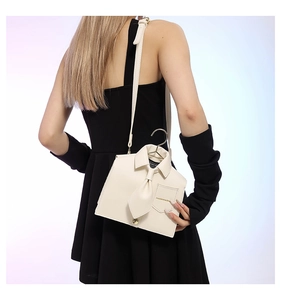 Rear view of model wearing a cream creative shirt-shaped bag with gold handle