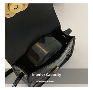 Detailansicht der kleinen Krokodilledertasche mit Fokus auf das Innenfach für Kosmetik