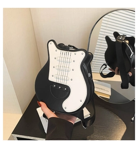 Detailed view of guitar-shaped shoulder bag featuring black and white contrast leather and studs