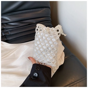 Detail of white handmade pearl bucket bag with hollow mesh and satin drawstring lining