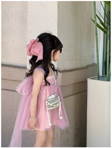 Detail of a mini pink girl's bag with pearls and rhinestones on a sweet tulle princess dress