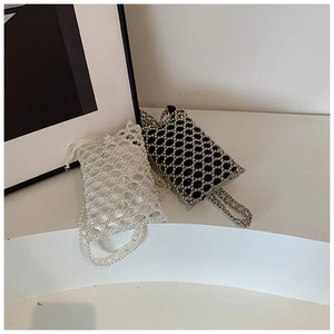 Detail of handcrafted beaded mini bags with pearl white and black hollow grid weave patterns