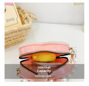 Detail showing the internal capacity of the pink heart-shaped mini bag with pearls