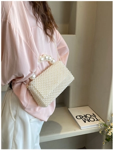 Detailed view of handmade white pearl woven handbag with elegant beaded strap and crossbody chain