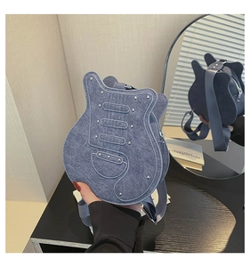 Detail view showing blue denim guitar shaped bag with silver metal studs and double zippers