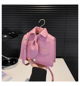 Detailed view of pink shirt-shaped bag with gold hanger handle and tie design