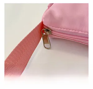 Detail of a smooth metal zipper and strap stitching on the pink canvas kids crossbody bag