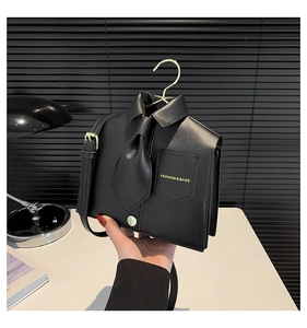 Detail of shirt-shaped handbag featuring a black tie and hanger hook handle