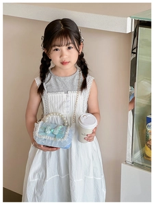 Detail of light blue kids handbag with large bow, pearl handle, and lace ruffles
