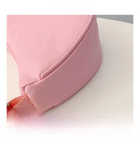 Close-up of pink semi-circular kids crossbody bag showing fine stitching and nylon fabric