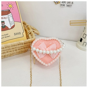 Detail of pink heart-shaped mini bag with pearl handle and mesh bow for kids