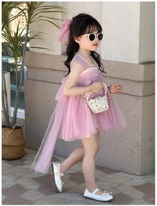 Detail of pink girls' tulle dress with matching pearl handbag and bow accessory
