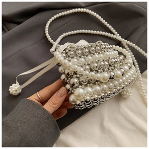 Detail of woven faux pearl and silver metal ball crossbody bag with silk bow closure