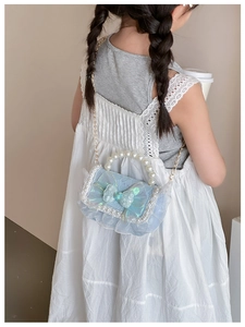 Detail view of mini blue lace girls' crossbody bag with pearl handle and bow