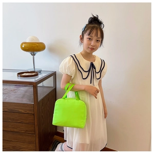 Neon green canvas lunch bag with dual handles shown in a minimalist home interior