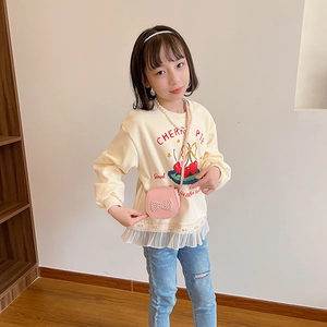 Sac bandoulière rose enfant avec nœud en perles, porté avec sweat à motif cerise
