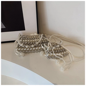 Detail of beaded mini bags featuring white pearls, silver beads, and silk ribbons
