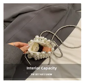Detail view of the mini pearl bag interior with white lining and silver metal chain strap