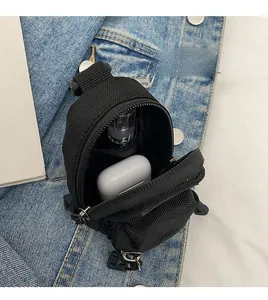 Internal view of a black mini canvas backpack bag showing storage for AirPods and small items