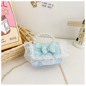 Detail of light blue girls' handbag featuring pearl handle and lace ruffles