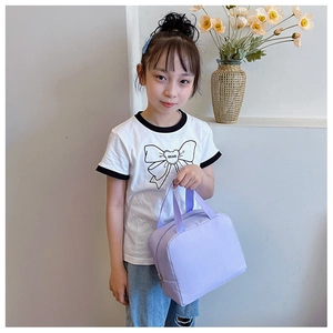 Close-up of child holding light purple canvas lunch bag with wide durable handles