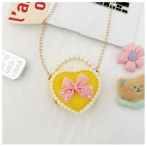 Detailed macro view of heart-shaped handbag with pearl handle and lace edging decoration