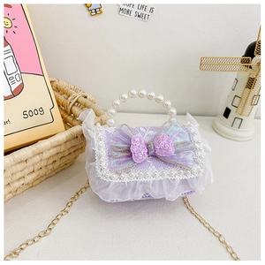 Detail of purple children handbag with lace edges, sequin bow, and pearl handle charm