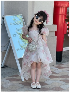 Detail of sweet floral girl dress with puff sleeves and elegant pearl handbag