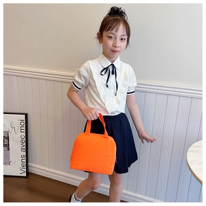Close-up of bright orange insulated canvas lunch bag with zipper and fabric handles