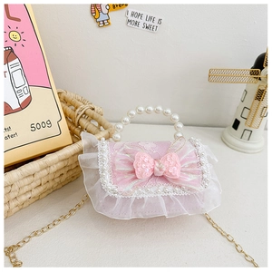 Detail of pink sequins bow and white lace trim on the girls crossbody chain bag
