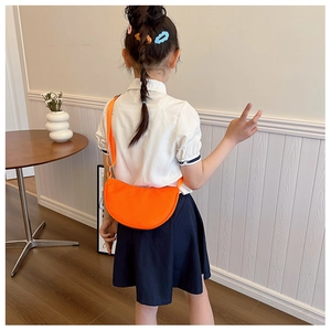 Detail showing bright orange kids crescent bag with adjustable wide fabric strap