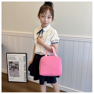 Pink minimalist canvas lunch bag for kids with durable handles shown in a lifestyle setting