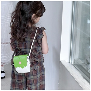 Vue détaillée du sac bandoulière enfant avec rabat ondulé vert et base en cuir blanc