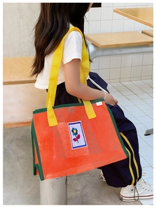 Détail du sac à bandoulière en résille orange vif pour enfant avec écusson floral