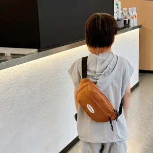 Marsupio minimalista per bambini in tela marrone caramello con tracolla sportiva