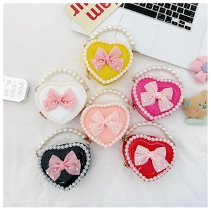 Flat lay showing heart-shaped mini bags in six colors with pearl handles and bows