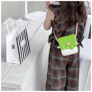 Détail du mini sac bandoulière enfant blanc et vert avec rabat ondulé et bouton rose
