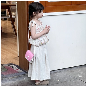 Sac bandoulière nuage rose et blanc porté avec une tenue de fille à pois colorés